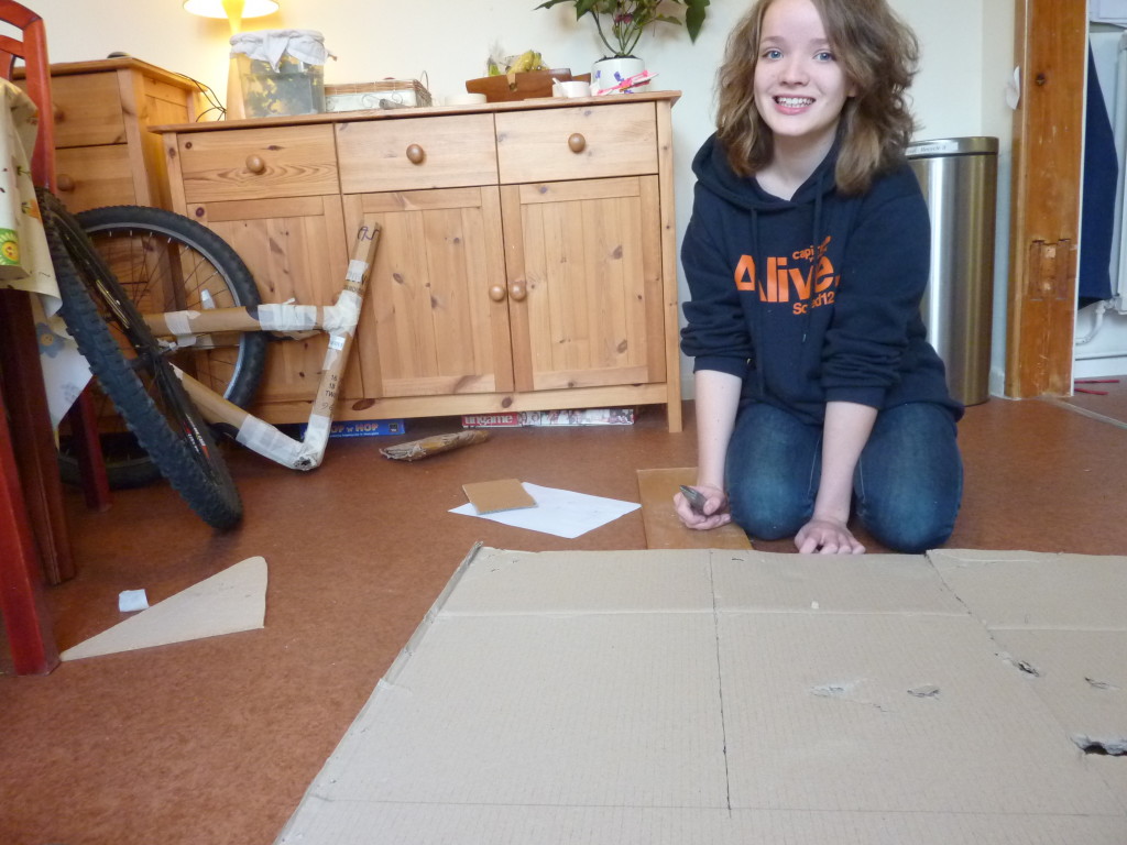Building a cardboard bike starts with a big sheet of cardboard